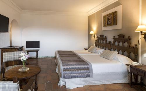 锡古恩萨席昆沙帕拉多尔酒店的酒店客房设有两张床和一张桌子。