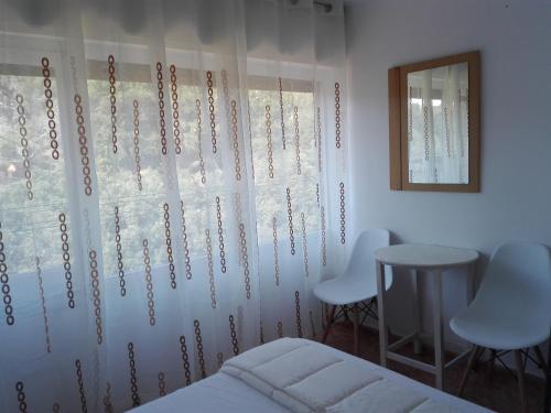 卡里拉UN ESPACIO DONDE CREAR GRANDES RECUERDOS的一间卧室配有一张床、两把椅子和一个窗户