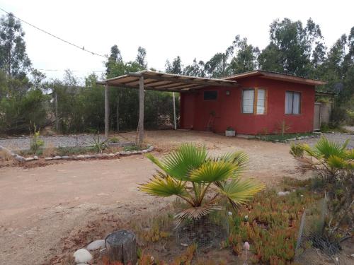 El TotoralCabañita Totoverde的一座小红房子,在院子里有树木