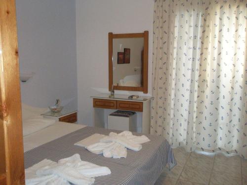 阿穆迪亚Ionio Gastronomy Suites的酒店客房,配有床和镜子