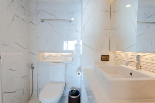 乔木提恩海滩芭堤雅乔木提恩海滩酒店的白色的浴室设有卫生间和水槽。