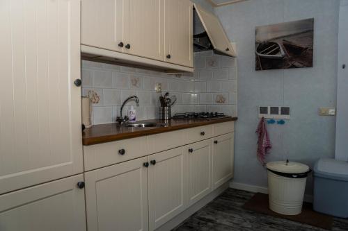 圣安娜兰Chaletparc Krabbenkreek Zeeland - Chalet 50的厨房配有白色橱柜和水槽
