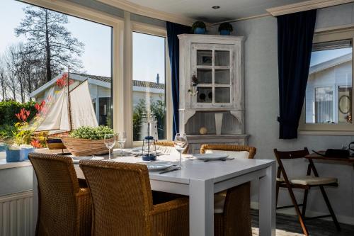 圣安娜兰Chaletparc Krabbenkreek Zeeland - Chalet 50的一间配备有白色桌椅的用餐室