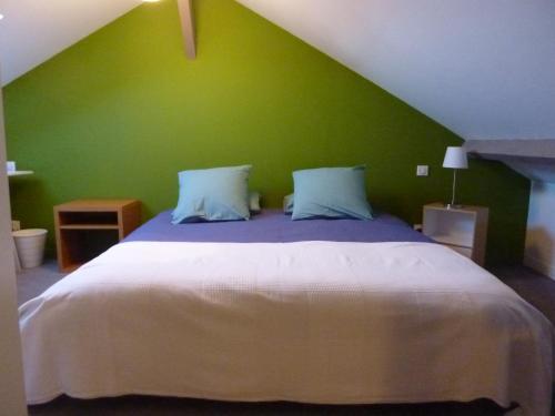 塔布Etage privatif的一间卧室设有一张大床和绿色的墙壁