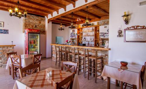 伊奥斯乔拉双子村庄旅馆的一间带桌椅的餐厅和一间酒吧