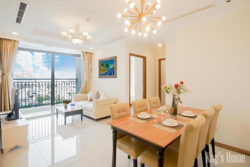 胡志明市Vinhomes Premium Apartment的用餐室以及带桌椅的起居室。