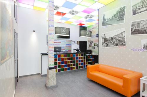 马德里JC客房圣多明各酒店的色彩缤纷的天花板,房内的橙色沙发