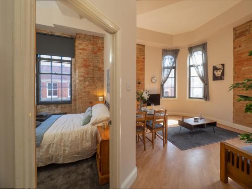 诺丁汉Apartment 16 Broadway House的一间卧室配有一张床,另一间用餐室配有桌子