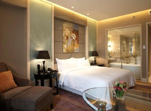 北京北京文津国际酒店的一间卧室配有一张床、一把椅子和一张沙发