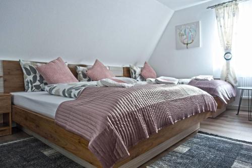 巴特法灵博斯特尔Hotel Zum Böhmegrund的卧室配有带粉红色枕头的大型木质床
