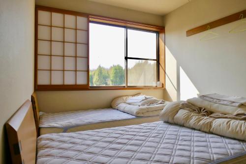 富士宫市FWA旅馆的客房设有两张床和大窗户。