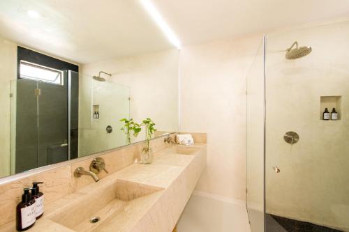 萨尤利塔Avela Boutique Hotel的一间带两个盥洗盆和淋浴的浴室