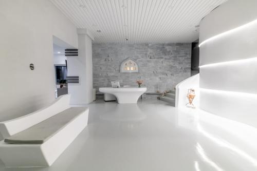 提诺斯拜占庭市酒店的白色的浴室设有石墙和水槽