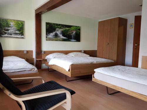 施泰因Garni-Hotel Mühletal的一间设有三张床和椅子的房间