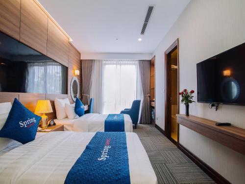 河内Spring Hotel Hanoi的酒店客房设有两张床和一台平面电视。