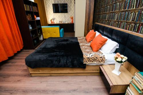 第比利斯Check Inn Tbilisi的一间卧室配有带橙色和白色枕头的床