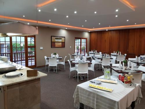 弗莱海德Shonalanga Lodge的一间设有白色桌子和白色椅子的餐厅