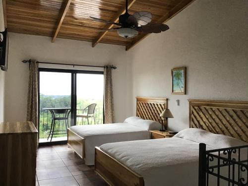 卡维塔Hotel Los Cielos Del Caribe的一间卧室配有两张床和吊扇