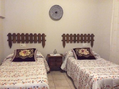 阿尔格达斯Apartamento Rural Castildetierra的一间卧室设有两张床,墙上挂着一个时钟。
