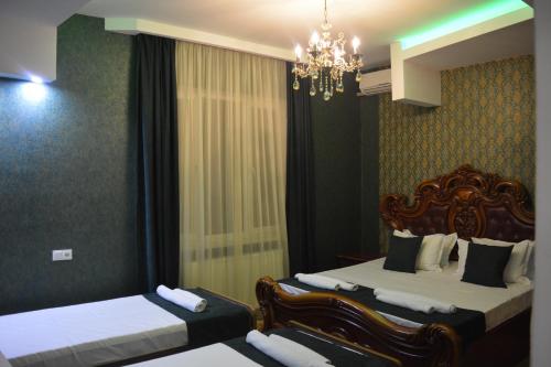 阿哈尔齐赫Millennium Rabati的酒店客房设有两张床和吊灯。