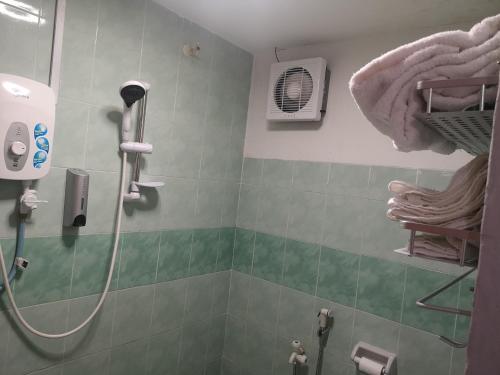 怡保Home Inn Hotel的带淋浴的浴室、风扇和毛巾
