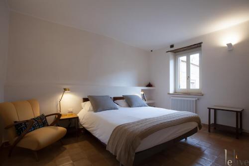 塞尔莫内塔Lelive Bed and Breakfast的卧室配有一张白色大床和一把椅子