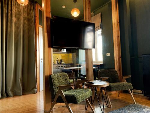 华沙欧迪南卡安眠公寓的客厅配有桌子和平面电视。
