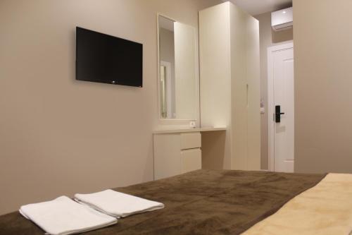 地拉那Star Hotel Astir的卧室配有一张壁挂式平面电视的床。