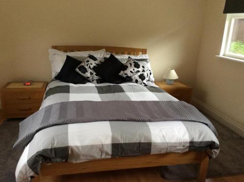 阿什福德The Firs的一张配有黑白毯子和枕头的床