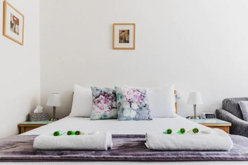 格莱内尔格Hi 5 Glenelg Studio Apartment的一张带枕头的白色床和绿色水果
