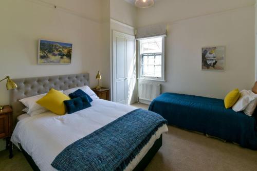 比奇沃斯Elm Tree Lodge Beechworth的一间卧室配有两张带蓝色和黄色枕头的床