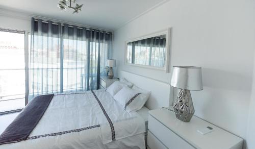 里斯本Charming Apartment with Balcony & Pool的白色的卧室设有床和窗户