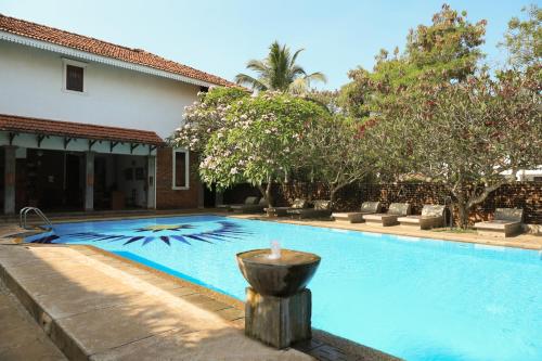 尼甘布阿拉利亚别墅酒店的一座房子前面带喷泉的游泳池