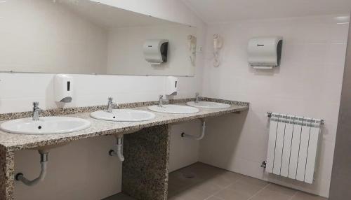 洛里加Loriga Hostel - Feel Nature的一间设有三个盥洗盆和镜子的公共浴室