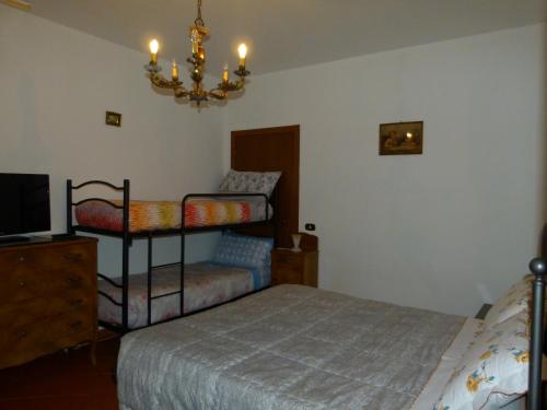 乌尔比诺B&B La Poiana的一间卧室配有一张床、一把椅子和一个吊灯。