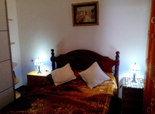 拉斯加莱塔斯A cozy flat in the heart of El Fraile的一间卧室配有一张带两盏灯的床。
