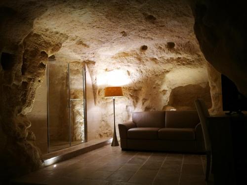 马泰拉5 Elementi Sassi Matera的客厅配有沙发和山洞里的灯