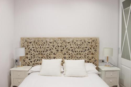 格拉纳达Morente sueña La Alhambra的一间卧室配有一张带2个床头柜的大型白色床