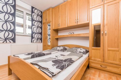 茨里克韦尼察Villa Mara的一间带一张床和木制橱柜的小卧室
