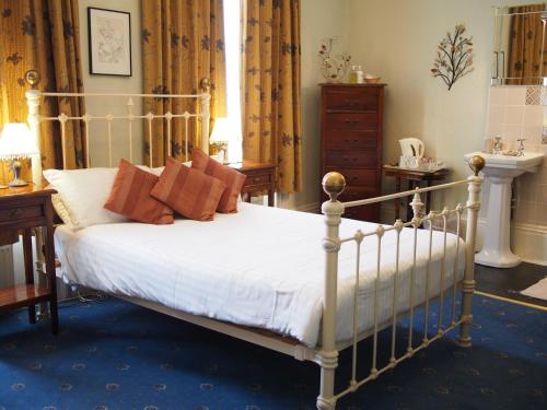 坎特伯雷The Coach House的一间卧室配有带白色床单和红色枕头的床。