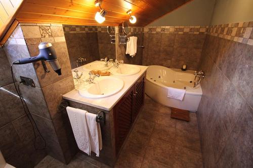 Navia de SuarnaCasa Suarna的浴室配有两个盥洗盆和浴缸。