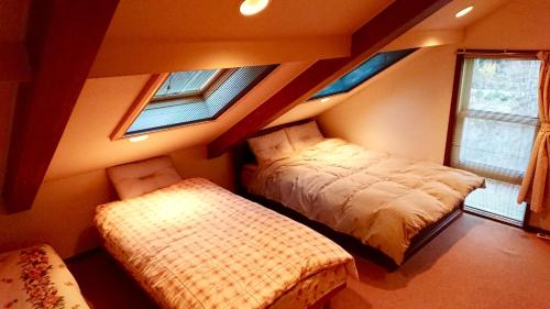 北斗市Guest House 合歓木（ねむ）的一间卧室设有两张床和两个窗户。