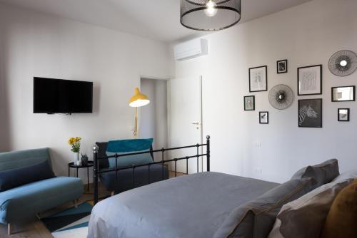 佛罗伦萨B&B La Marmora 39的一间卧室配有一张床、一把椅子和电视。