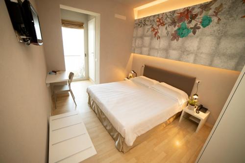 里瓦迪索尔托米兰达酒店的一间卧室配有一张床,墙上配有电视