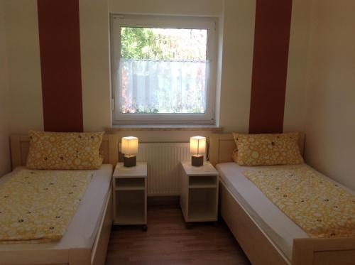 HarthausenFerienwohnungen Bella Vita的配有两张床铺的房间,配有两盏灯