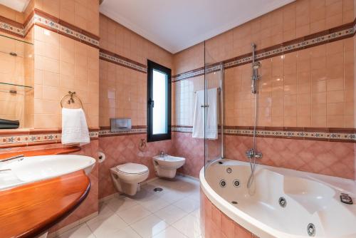 马拉加CASA MIRAFLORES的带浴缸、卫生间和盥洗盆的浴室