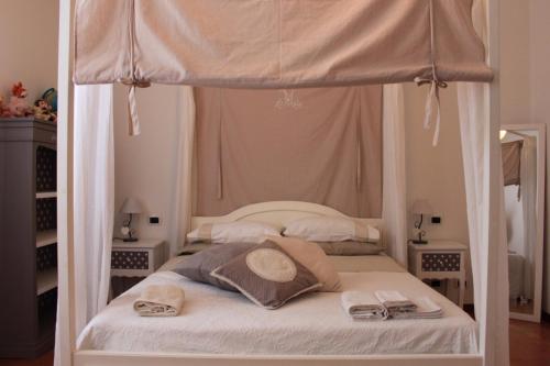 San Trovasocasa vacanza Pina的一间卧室配有一张带毛巾的天蓬床。