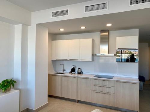 马拉加Diamond Apartments Puerto De Malaga的厨房配有白色橱柜和台面