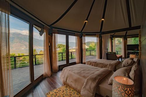 博卡拉The Pavilions Himalayas Lake View的一间带两张床的卧室和一个窗户阳台