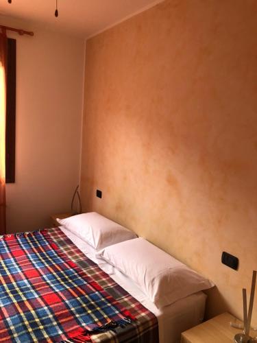博洛尼亚Michelino's house的一间卧室配有一张带彩色毯子的床